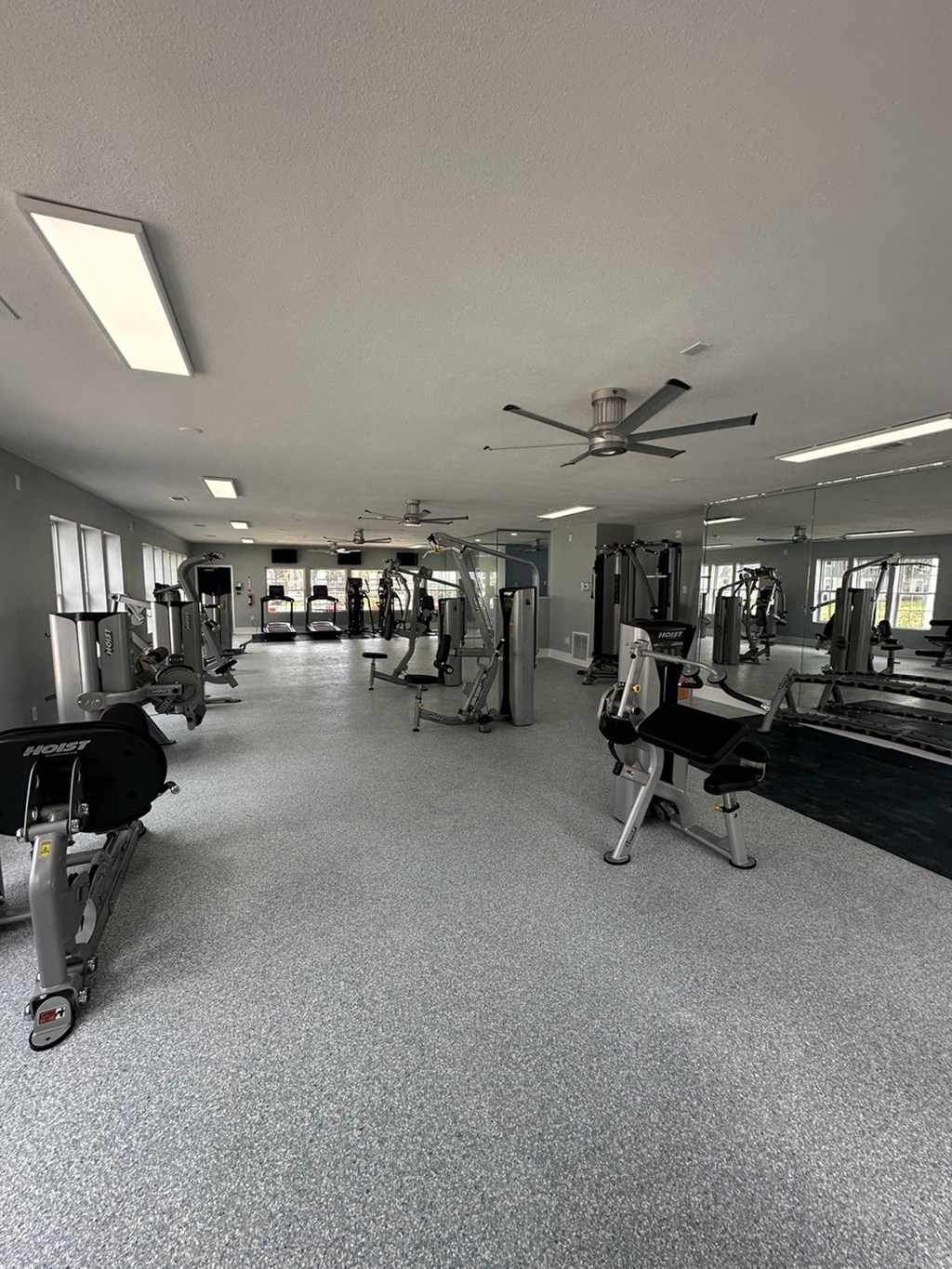 a gym with weights machines and a ceiling fan